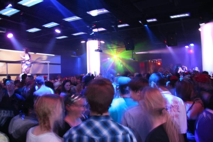 Crowded dance floor with colorful lighting and video projections